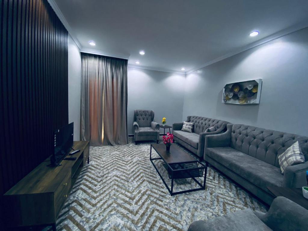 شقق الكوثر الفندقية في مكة المكرمة: غرفة معيشة بها أريكة وتلفزيون
