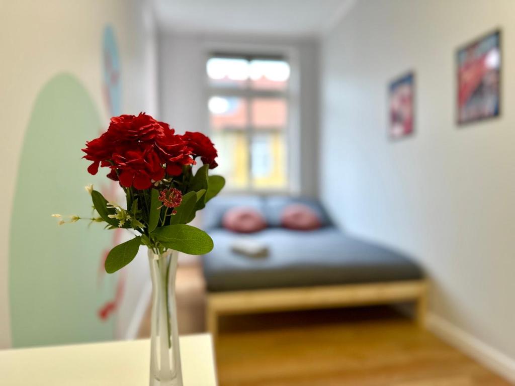 a vase filled with red roses sitting on a table at Samurai Room in Gdańsk