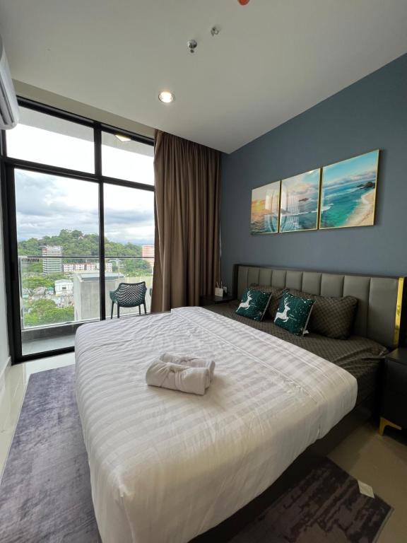 - une chambre avec un grand lit blanc et un canapé dans l'établissement NOSTRE HOMESTAY THE SHORE KK, à Kota Kinabalu