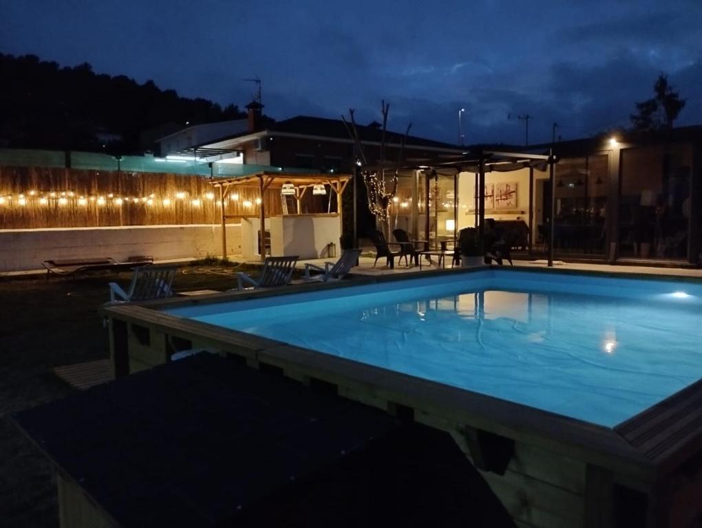 a swimming pool at night with lights on a building at Villa Franz House Casa de Invitados in Canyelles