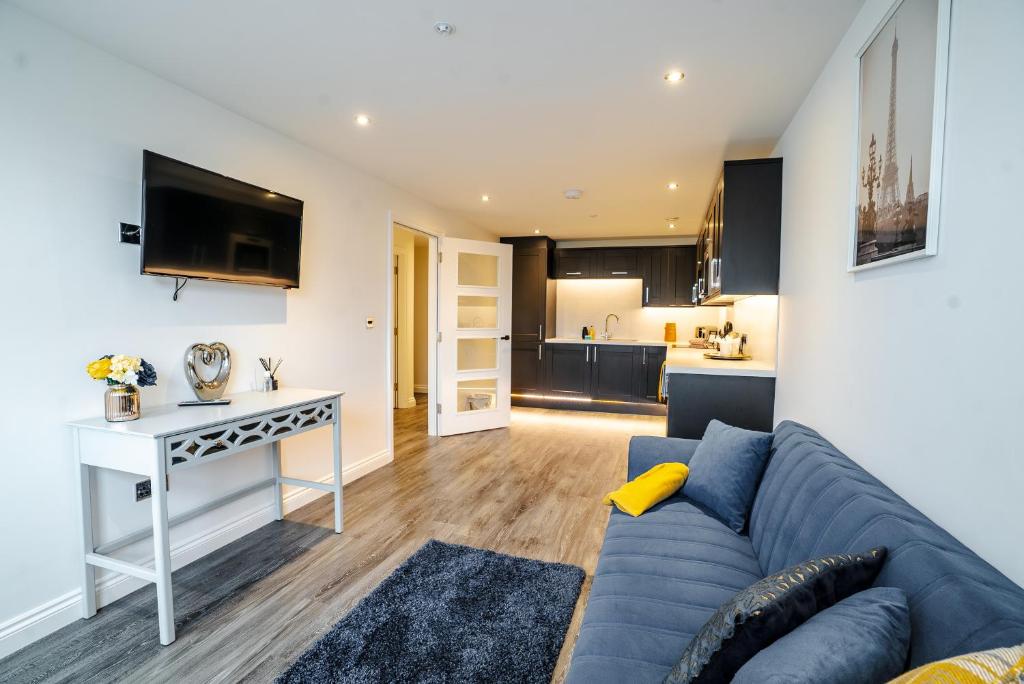 sala de estar con sofá azul y cocina en Stunning 1 bed flat in the heart of Brighton lanes, en Brighton & Hove