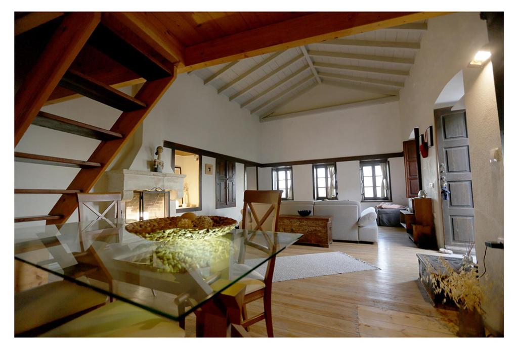 uma sala de estar com uma mesa de vidro num quarto em Daphne superior castle suite em Monemvasia