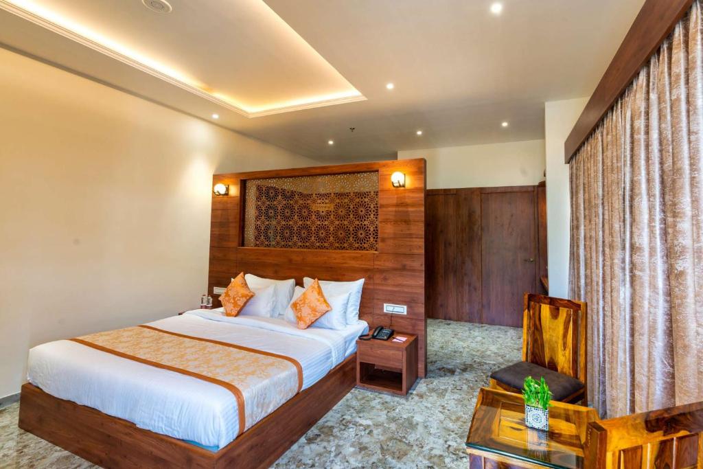 ein Hotelzimmer mit einem Bett und einem Stuhl in der Unterkunft The Grand Fateh in Udaipur