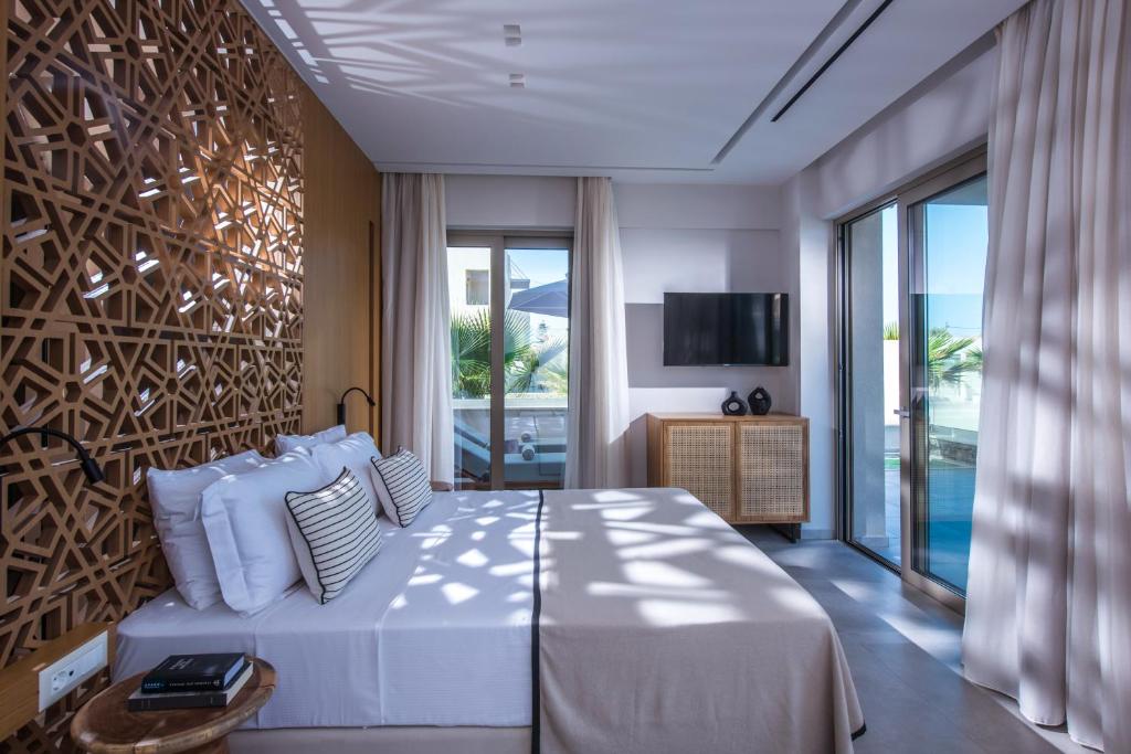 a bedroom with a large white bed and a television at Niriides Palace in Gournes