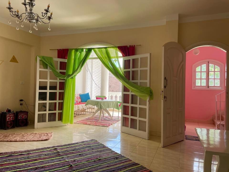 ルクソールにあるGreen homeの緑とピンクのドアが付いたリビングルーム