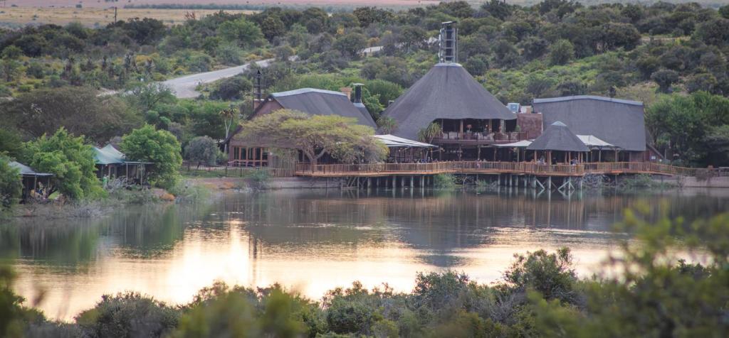 a building with a bridge over a body of water at Buffelsdrift Game Lodge in Oudtshoorn