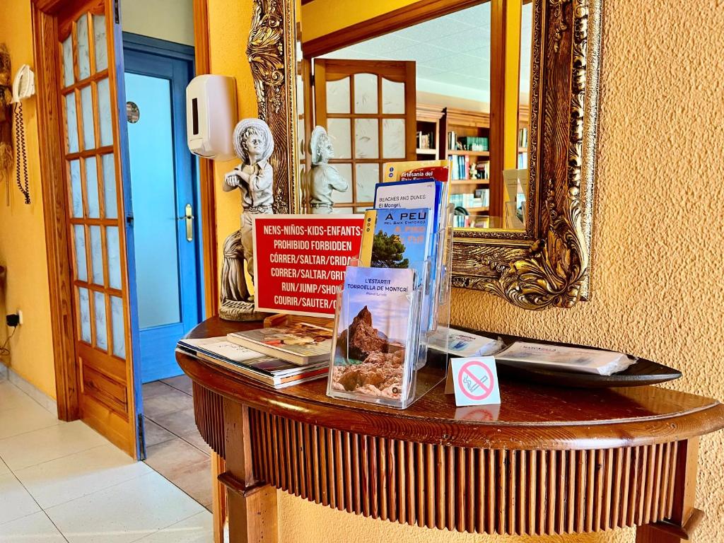 una mesa con un espejo y libros en ella en Casa Rural Hípica Mas Paguina en L'Estartit