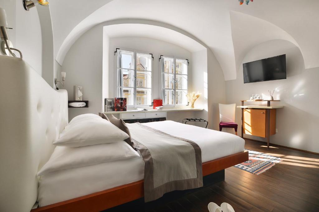 um quarto com uma cama e um lavatório num quarto em Design Hotel Neruda em Praga