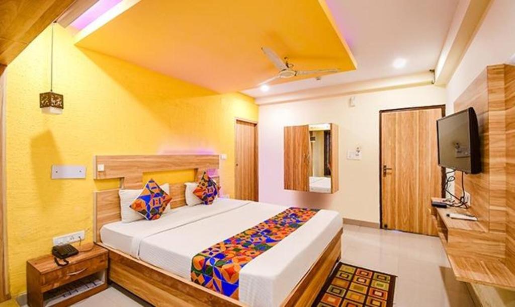 sypialnia z dużym łóżkiem i telewizorem w obiekcie FabHotel Sai Jagannath Residency w mieście Khandagiri