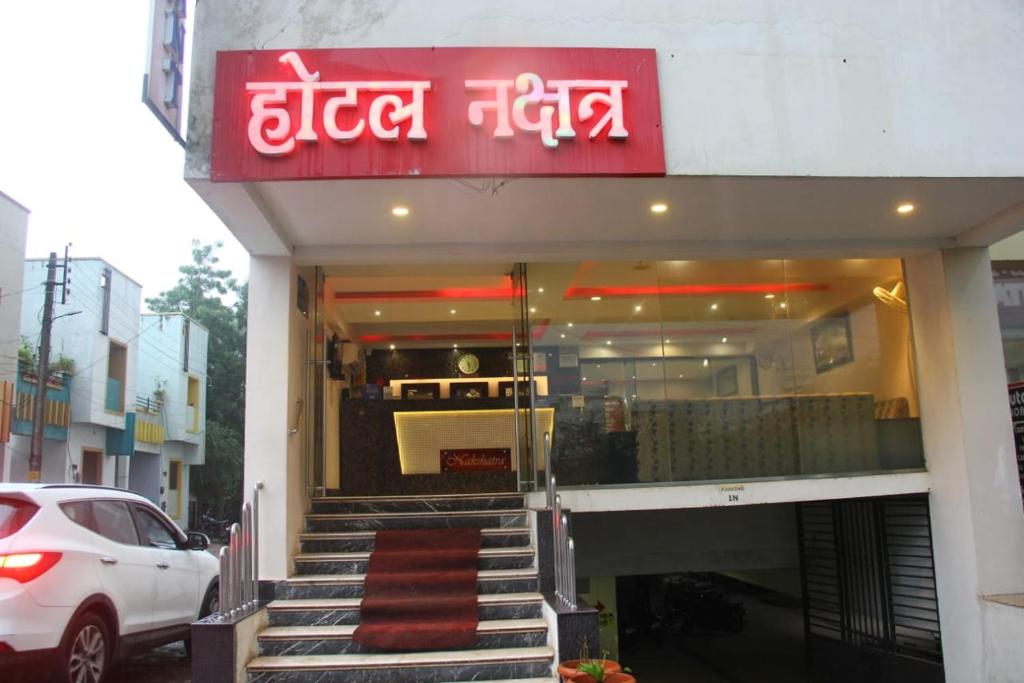 a store front with a red sign on a building at Nakshatra Hotel in Bānswāra