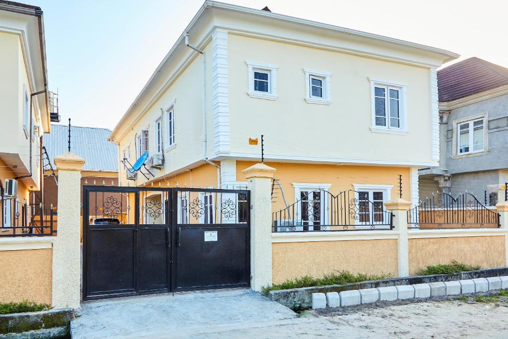 una casa grande con una puerta negra delante de ella en Mainstream Shortlet Apartments, en Gbogije