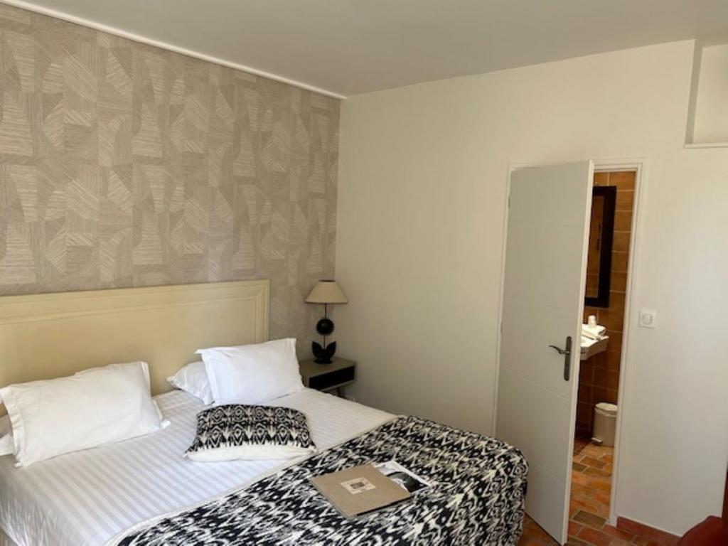 - une chambre avec un lit et un livre dans l'établissement Mas des Carassins, à Saint-Rémy-de-Provence