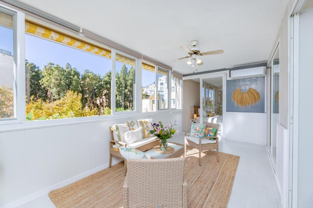 un soggiorno con tavolo, sedie e finestre di Apartamento excelente ubicación cerca de la playa a Marbella
