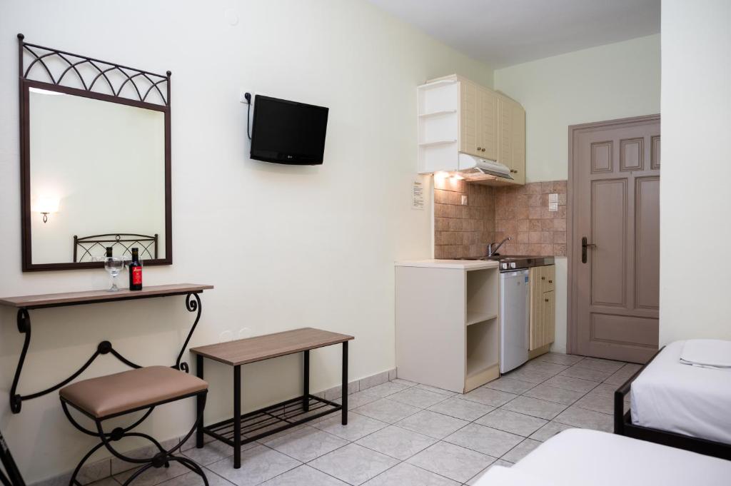 a small room with a desk and a bed and a kitchen at Konstantinos Hotel & Apartments 2 in Nydri