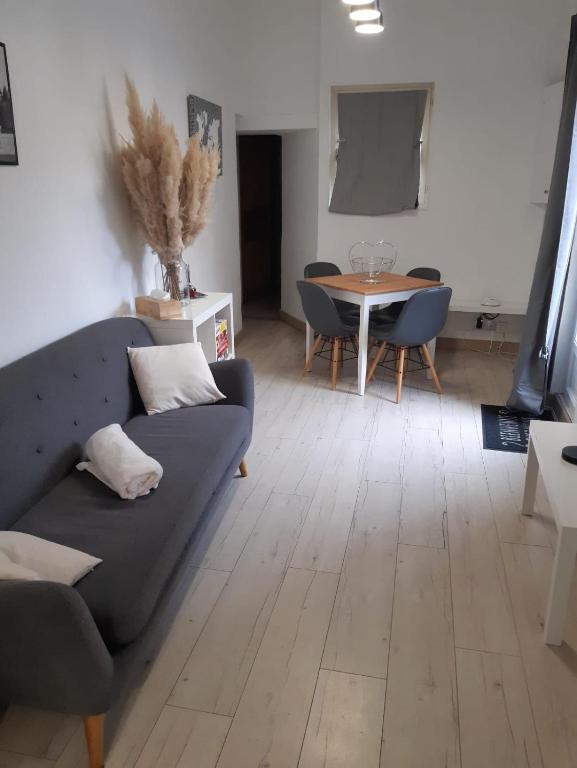 a living room with a couch and a table at Charmante maison dans le Gers, proche lac et centre-ville in LʼIsle-Jourdain