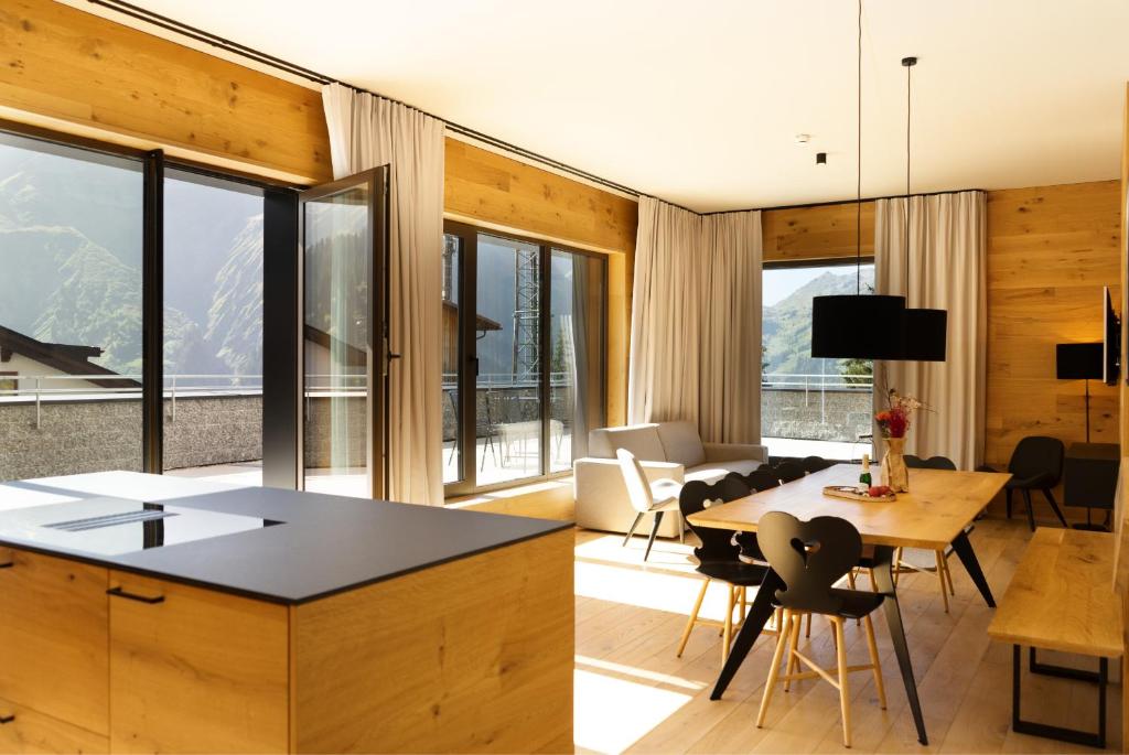 uma cozinha e sala de estar com mesa e cadeiras em Heimat 1495 Appartements - TYP 7 em Schröcken