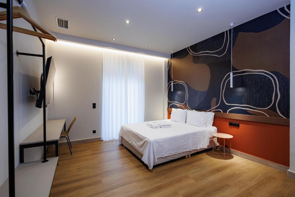 a bedroom with a bed and a table and a desk at K2 Suites Kalamata in Kalamata