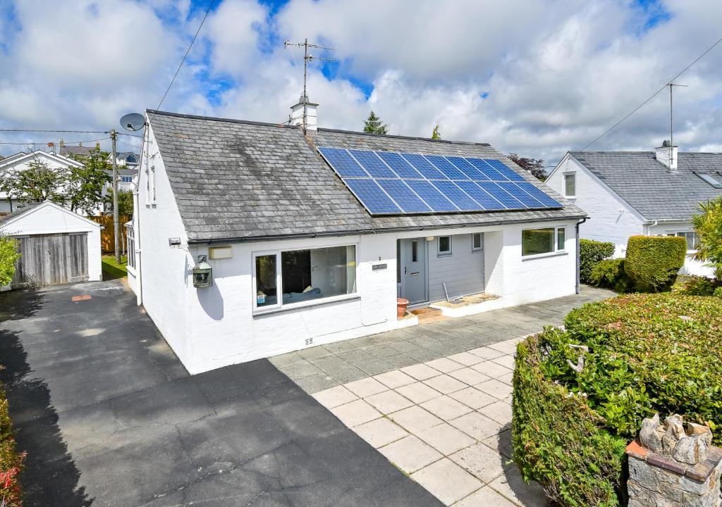 uma casa branca com painéis solares no telhado em Mor Gragen em Abersoch