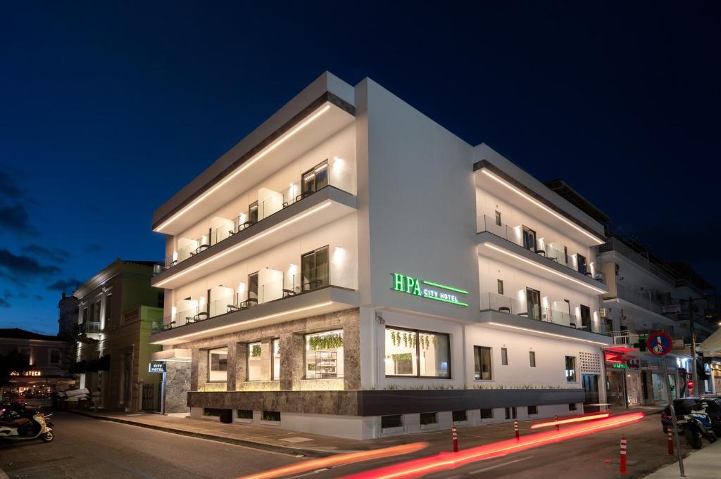 a white building on a city street at night at IRA - ΗΡΑ City Hotel in Kalamata