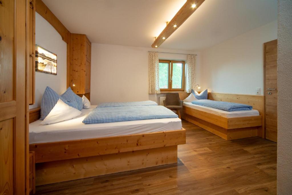 1 dormitorio con 2 camas y almohadas azules en Panoramablick Heimen, en Hopferau