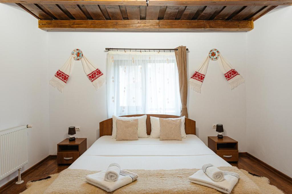 a bedroom with a bed with towels on it at Pensiunea Ioana in Poeni
