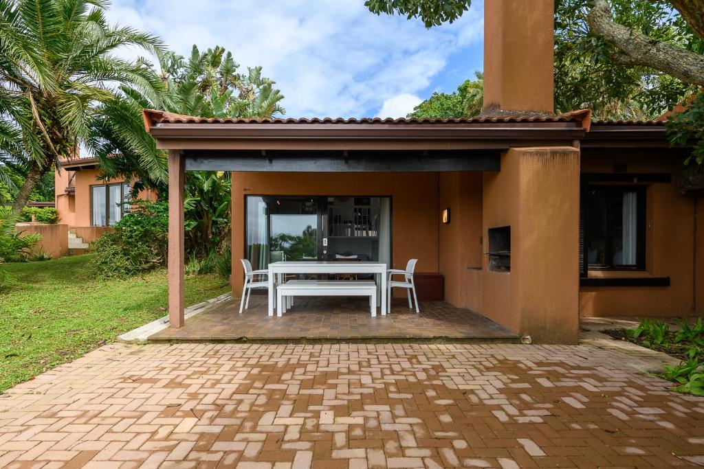 a patio with a white table and chairs at San Lameer Villa 2204 - 2 Bedroom Classic - 4 pax - San Lameer Rental Agency in Southbroom
