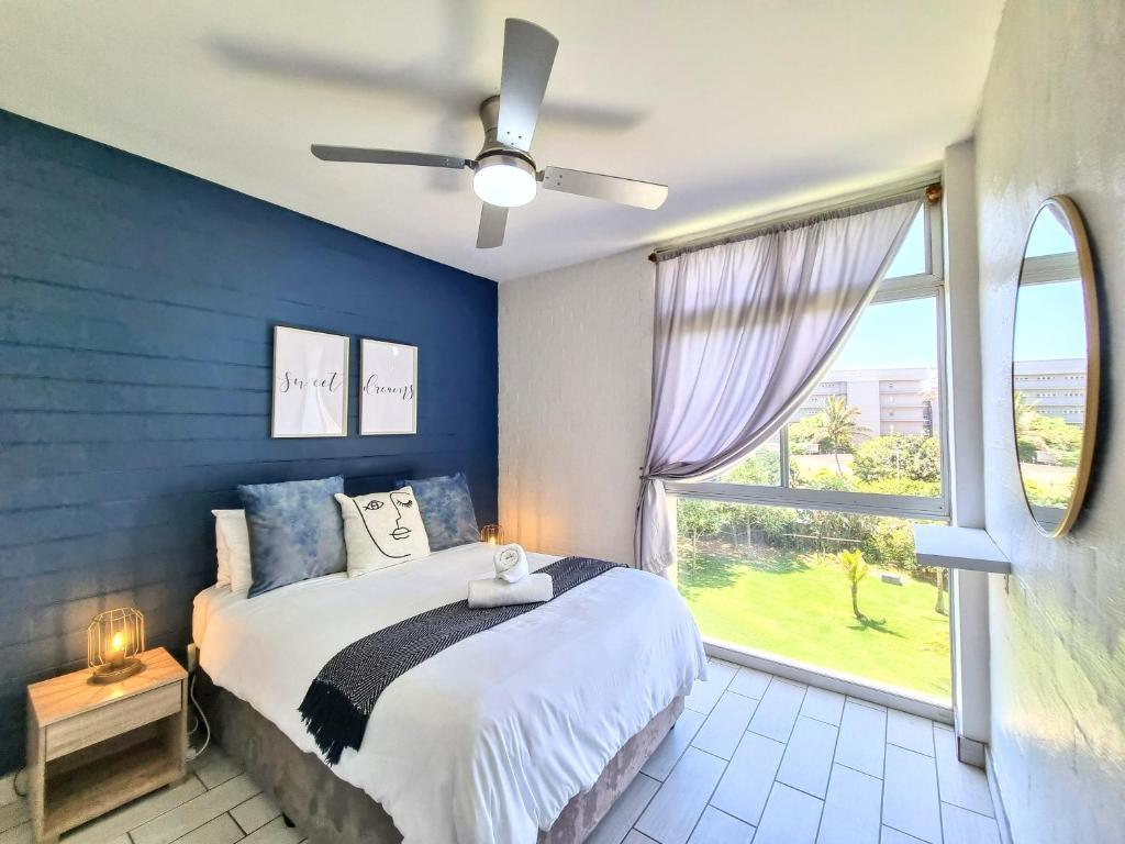 a bedroom with a bed and a large window at La Ballito 305 in Ballito