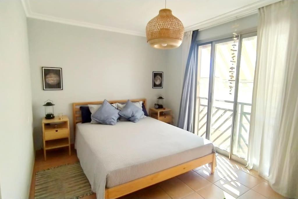 Apartamento El Faro, Sotavento, playa la tejíta في La Tejita: غرفة نوم بسرير ونافذة كبيرة