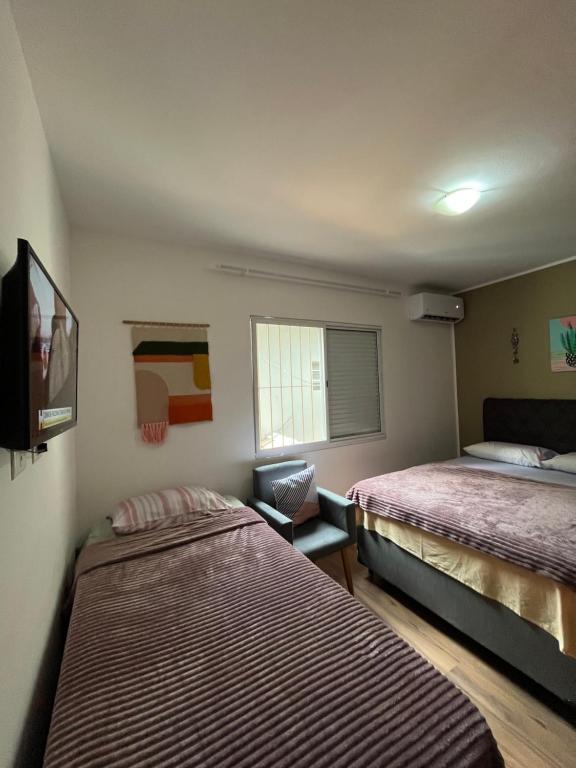 a room with two beds and a television in it at Casa do Zafer in Sao Paulo