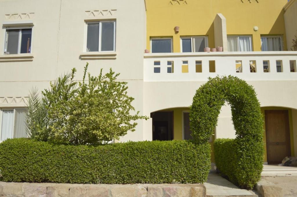 a building with a hedge in front of a building at f- ground floor with garden in Hurghada