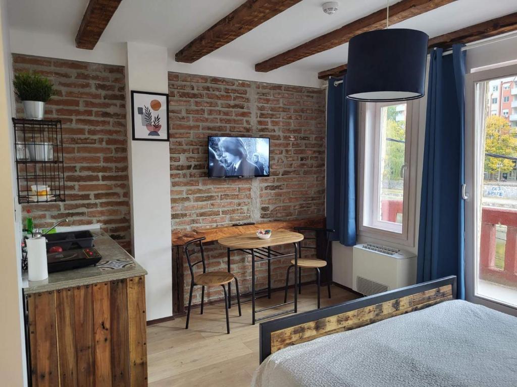 a bedroom with a bed and a table with chairs at Apartment By the River in Niš