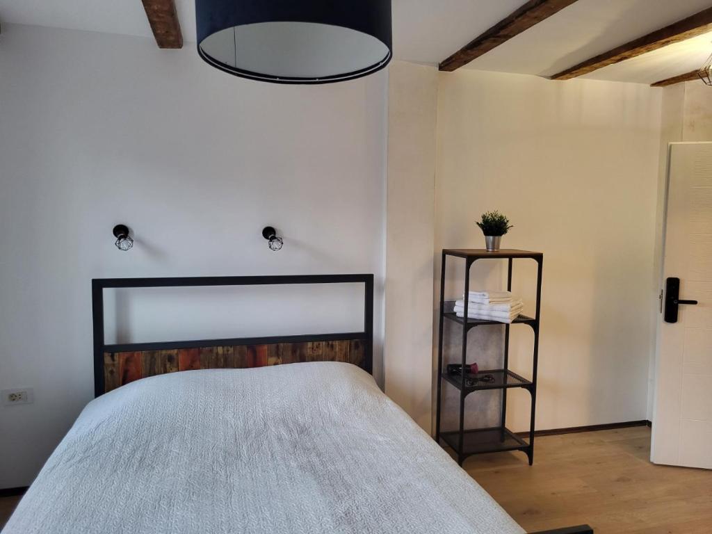a bedroom with a bed and a lamp at Apartment By the River in Niš