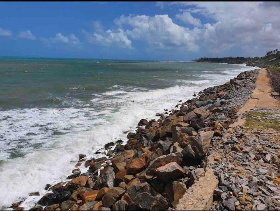 una costa rocosa con olas que chocan contra el océano en Alugo apartamento na praia, en Caucaia