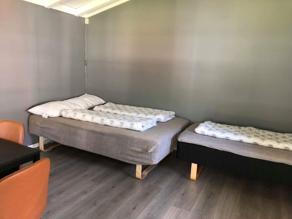 2 camas en una habitación con suelo de madera en Sølvgarden Camping, en Rysstad