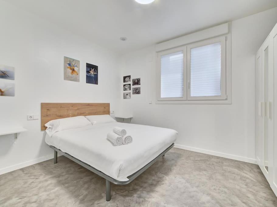 a white bedroom with a bed and a window at Apartment Sua Loft by Clabao in Pamplona