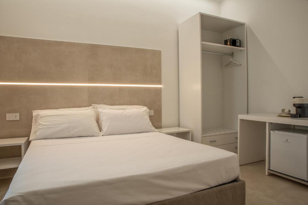 1 dormitorio con 1 cama grande con sábanas blancas en Room Corso 219, en Montesilvano