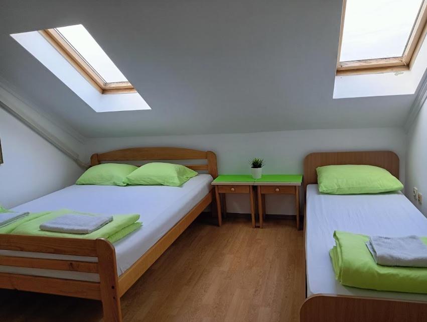 two beds in a room with two windows at Car Konaci in Smederevo