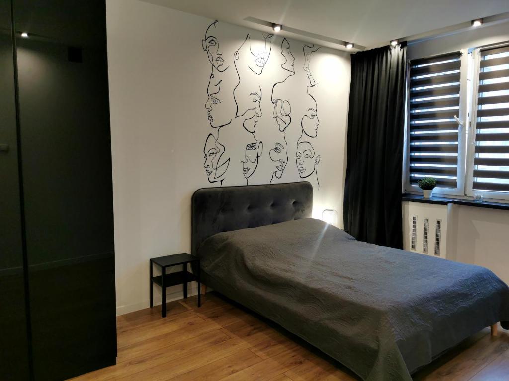 1 dormitorio con 1 cama con cabecero y ventana en Apartament Ceglany en Tychy