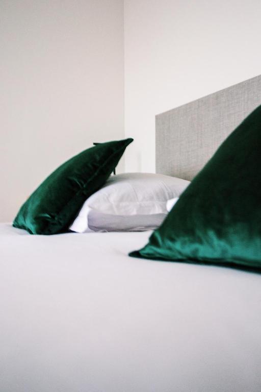a bed with two green pillows on top of it at ZILTE STILTE in Ostend