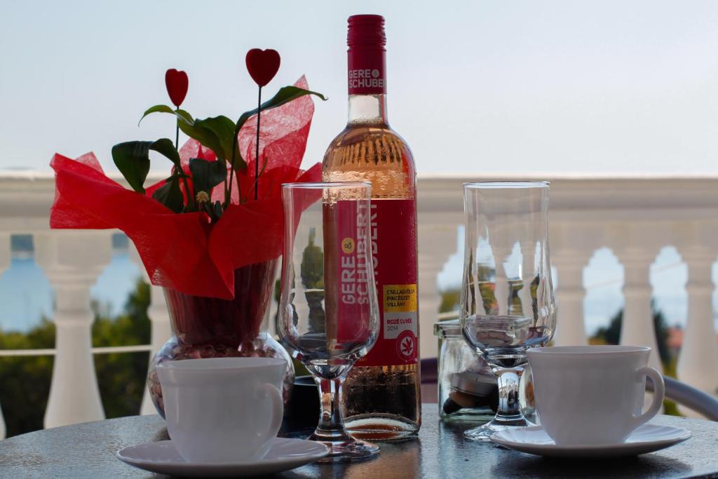 - une table avec une bouteille de vin et un vase avec des fleurs dans l'établissement Apartment Toni, à Primošten
