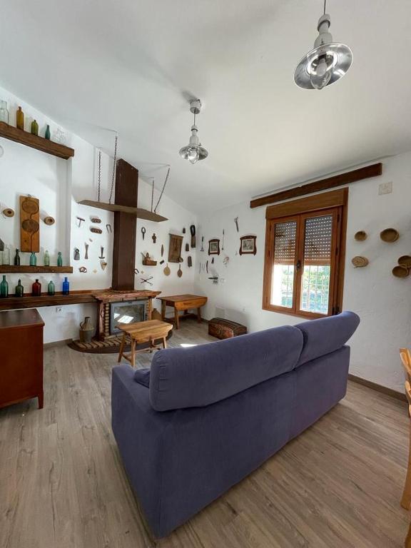 a living room with a blue couch and a table at Cortijo la Noria I in Puebla de Don Fadrique