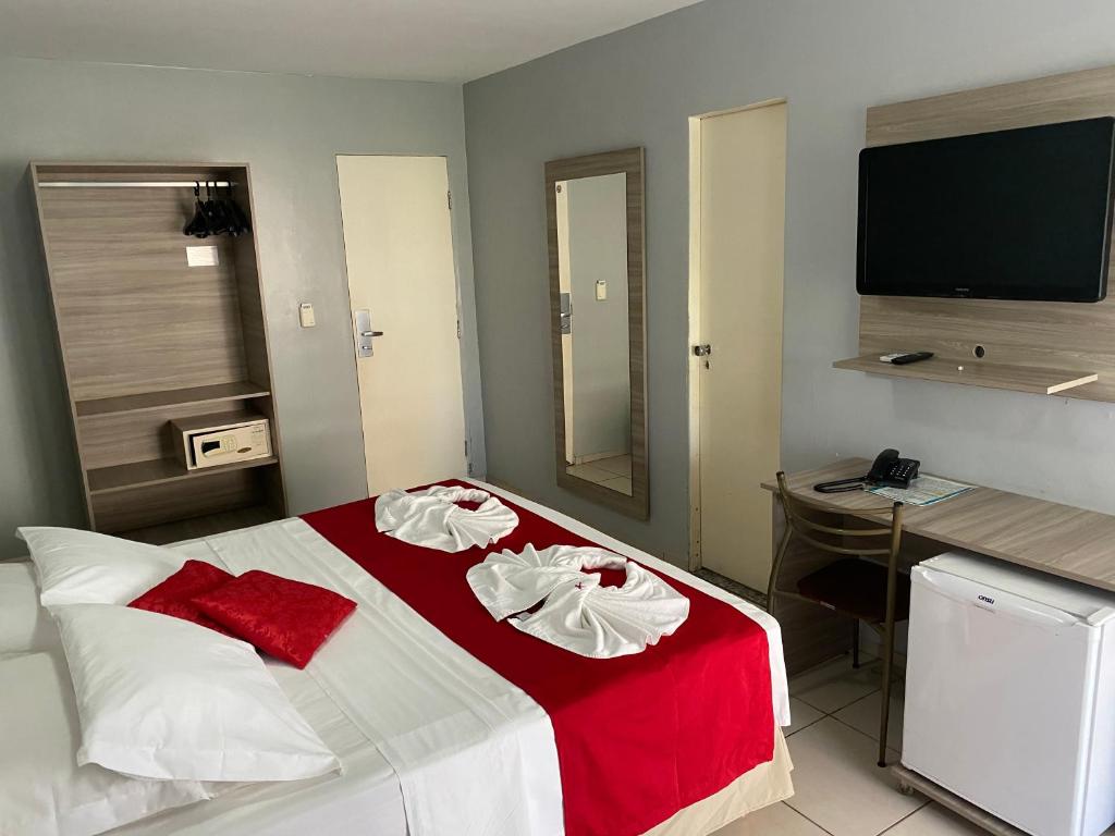 フォルタレザにあるHotel Fortaleza Innのベッドと机とテレビのある寝室