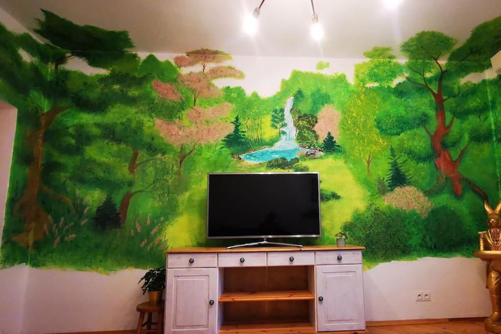 een tv op een dressoir met een schilderij aan de muur bij Cosy condo in Warschau