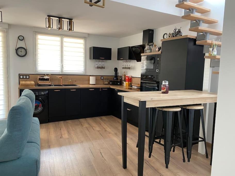 a kitchen with a table and a blue couch at Superbe Appartement atypique in Bouleternère