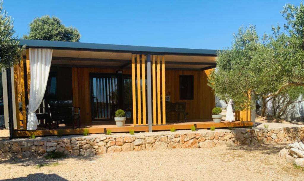 a small house with a stone wall at Beachfront Bliss - Vortex4BB in Tisno