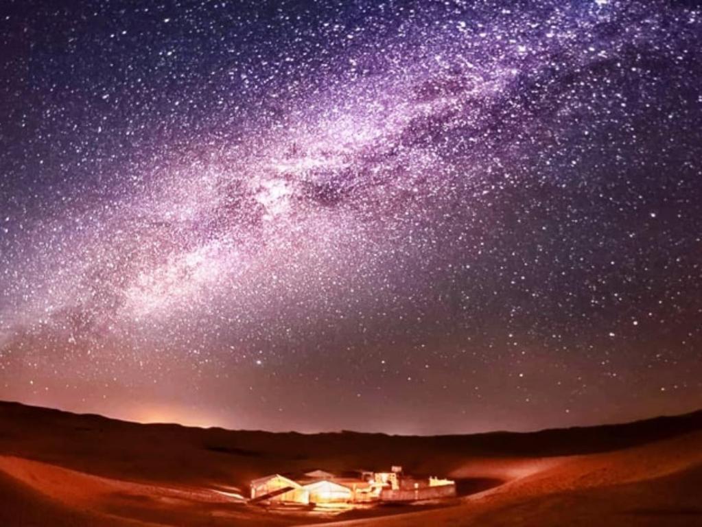梅尔祖卡Merzouga Comfortable Camps的一片星空,在沙漠中有一所房子