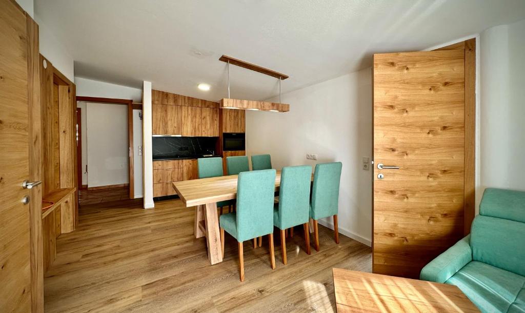 uma cozinha e sala de jantar com uma mesa de madeira e cadeiras em mountain view em Piesendorf