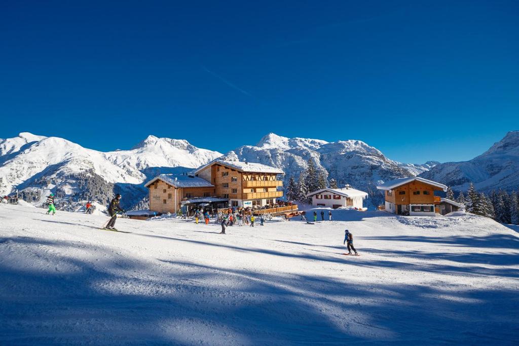 un grupo de personas esquiando en una montaña cubierta de nieve en Hotel Burgwald - Ski In & Ski Out, en Lech am Arlberg