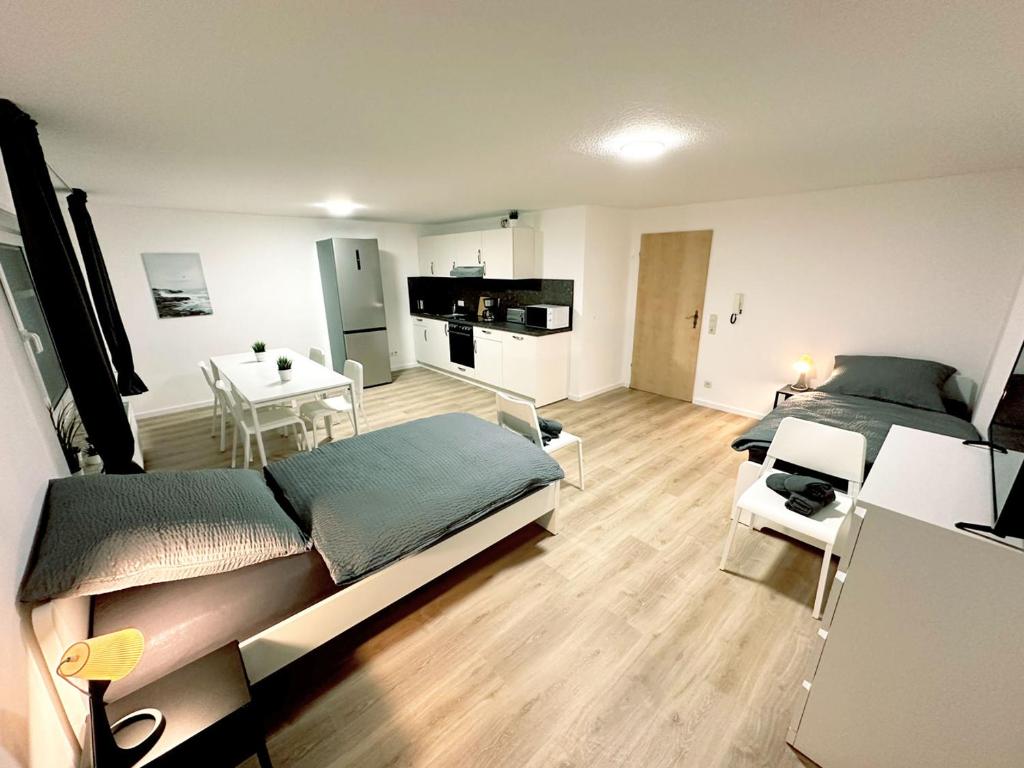 1 Schlafzimmer mit 2 Betten, einem Tisch und einer Küche in der Unterkunft Nice Apartment in Einbeck - Vogelbeck in Einbeck
