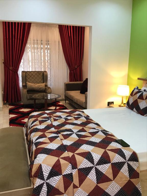 um quarto com uma cama, um sofá e uma cadeira em S.K PLAZA em East Legon